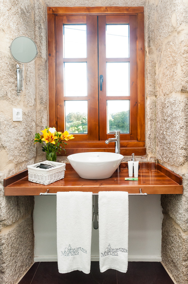 Foto di un piccolo bagno di servizio country con pavimento in legno massello medio, pareti bianche e lavabo a bacinella