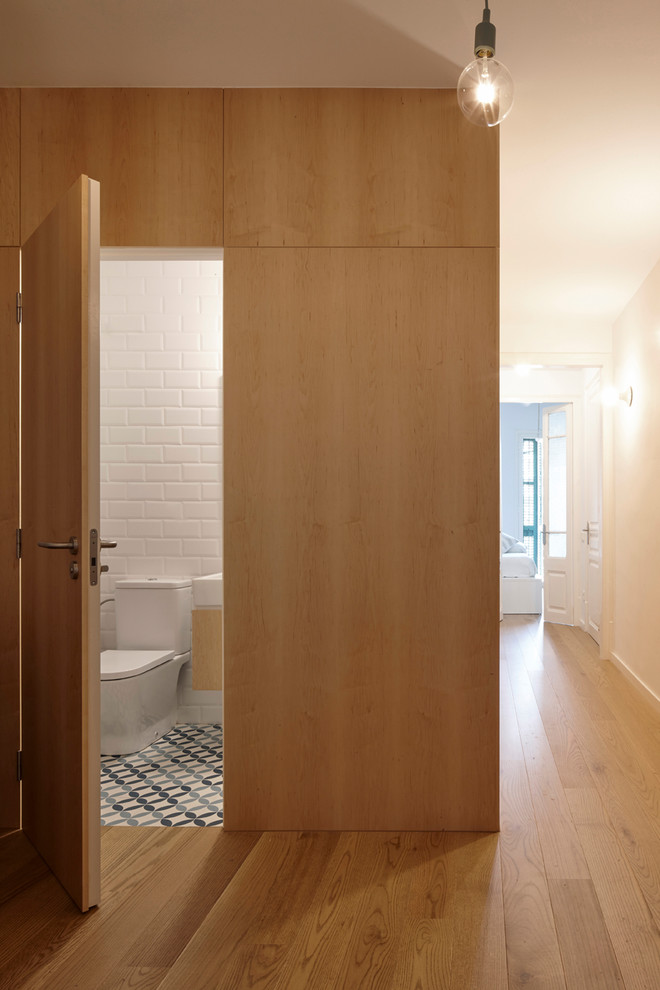 На фото: туалет среднего размера в средиземноморском стиле с раздельным унитазом, белой плиткой, белыми стенами, полом из керамической плитки, синим полом, плоскими фасадами, светлыми деревянными фасадами, плиткой кабанчик и консольной раковиной с