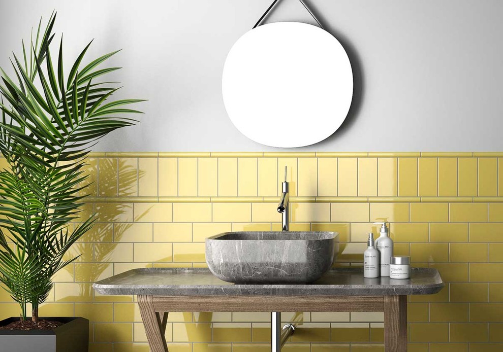 Idées déco pour un WC et toilettes moderne avec un carrelage jaune, des carreaux de céramique et un mur jaune.
