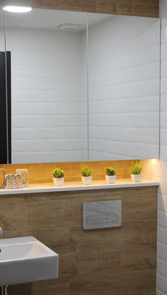 На фото: маленький туалет в средиземноморском стиле с фасадами с утопленной филенкой, инсталляцией, бежевой плиткой, белыми стенами, полом из керамической плитки, подвесной раковиной и бежевым полом для на участке и в саду
