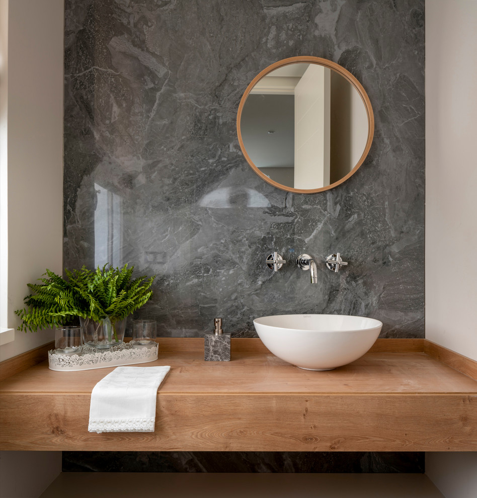 Inspiration för ett mellanstort nordiskt brun brunt toalett, med öppna hyllor, skåp i mellenmörkt trä, grå kakel, porslinskakel, ett fristående handfat, träbänkskiva och vita väggar