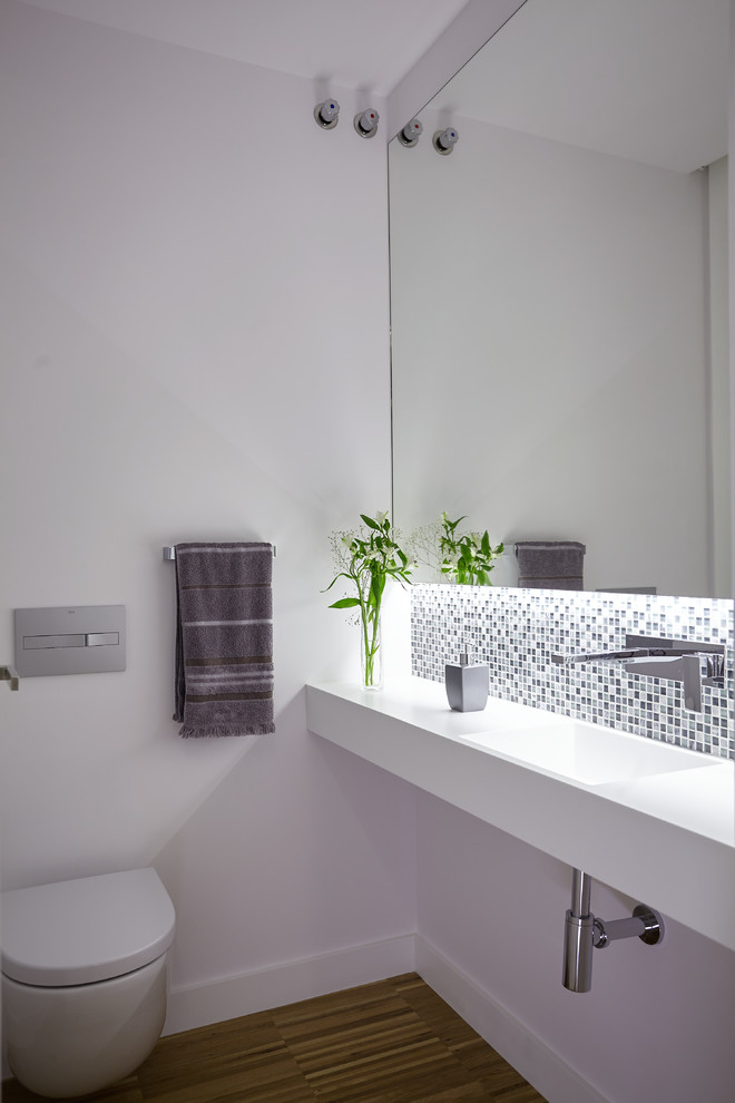Источник вдохновения для домашнего уюта: маленький туалет в современном стиле с белыми стенами, паркетным полом среднего тона, монолитной раковиной и инсталляцией для на участке и в саду