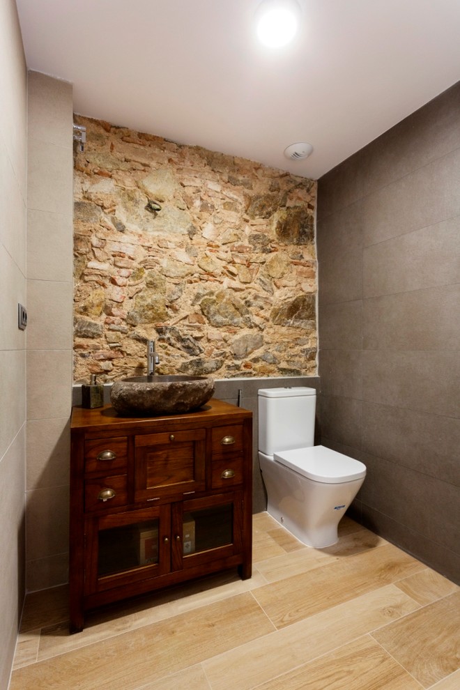 Ispirazione per un bagno di servizio stile rurale di medie dimensioni con ante lisce, ante in legno bruno, WC a due pezzi, pareti multicolore, parquet chiaro e lavabo a bacinella