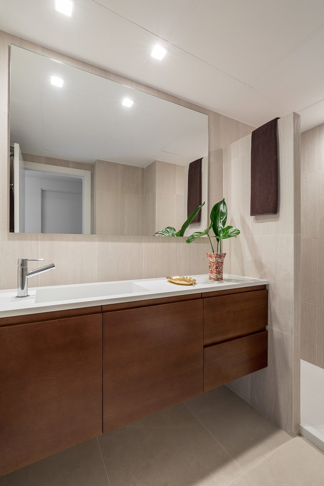 Idee per un piccolo bagno di servizio design con ante lisce, ante in legno bruno, pareti beige e lavabo integrato