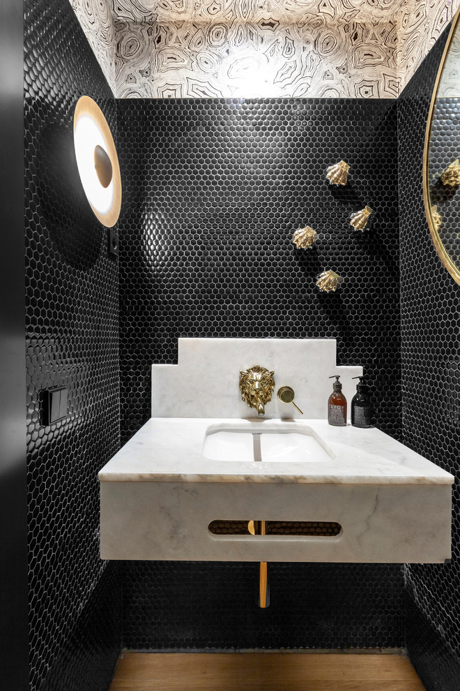 На фото: туалет в современном стиле с черной плиткой, плиткой мозаикой, разноцветными стенами, паркетным полом среднего тона, врезной раковиной, мраморной столешницей и серой столешницей