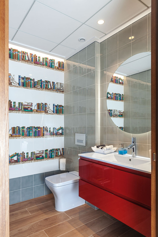 Immagine di un bagno di servizio design con ante lisce, ante rosse, WC monopezzo, piastrelle multicolore, lavabo a consolle e pavimento marrone
