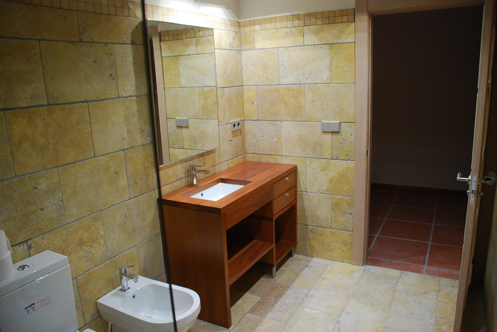 This is an example of a medium sized rustic cloakroom in Other with open cabinets, medium wood cabinets, a bidet and a submerged sink.