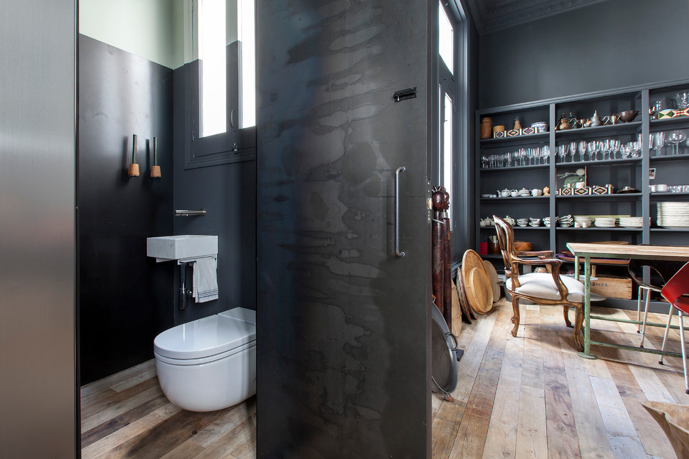 Esempio di un bagno di servizio industriale di medie dimensioni con WC sospeso, pareti grigie, pavimento in legno massello medio e lavabo sospeso