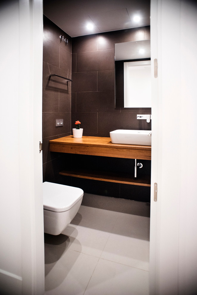 Idées déco pour un petit WC suspendu contemporain en bois brun avec un placard sans porte, un mur noir, un sol en carrelage de céramique et une vasque.