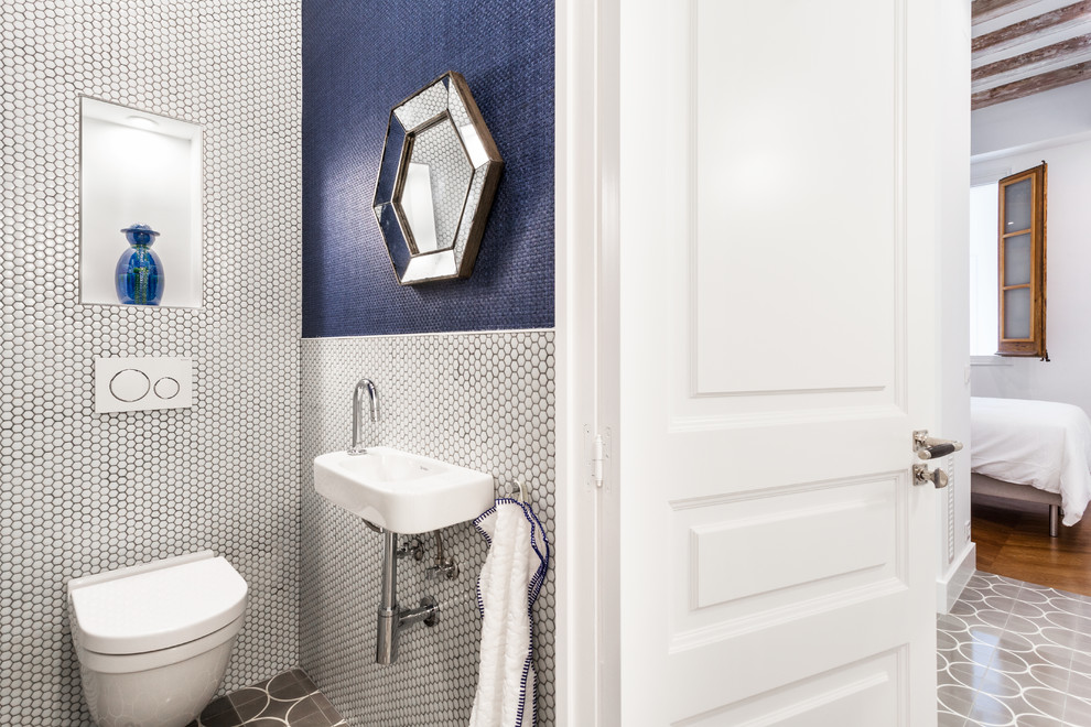 На фото: маленький туалет в современном стиле с инсталляцией, синей плиткой, белой плиткой, плиткой мозаикой, синими стенами, подвесной раковиной и разноцветным полом для на участке и в саду