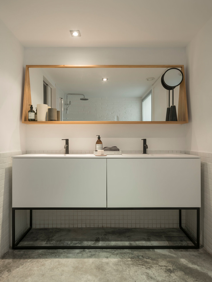 Пример оригинального дизайна: туалет среднего размера в стиле лофт с белыми фасадами, белой плиткой, керамической плиткой, белыми стенами, бетонным полом, серым полом и белой столешницей