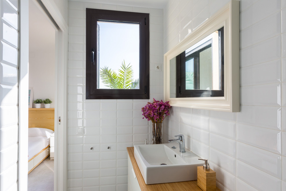 На фото: маленький туалет в средиземноморском стиле с плоскими фасадами, белыми фасадами, белыми стенами и настольной раковиной для на участке и в саду