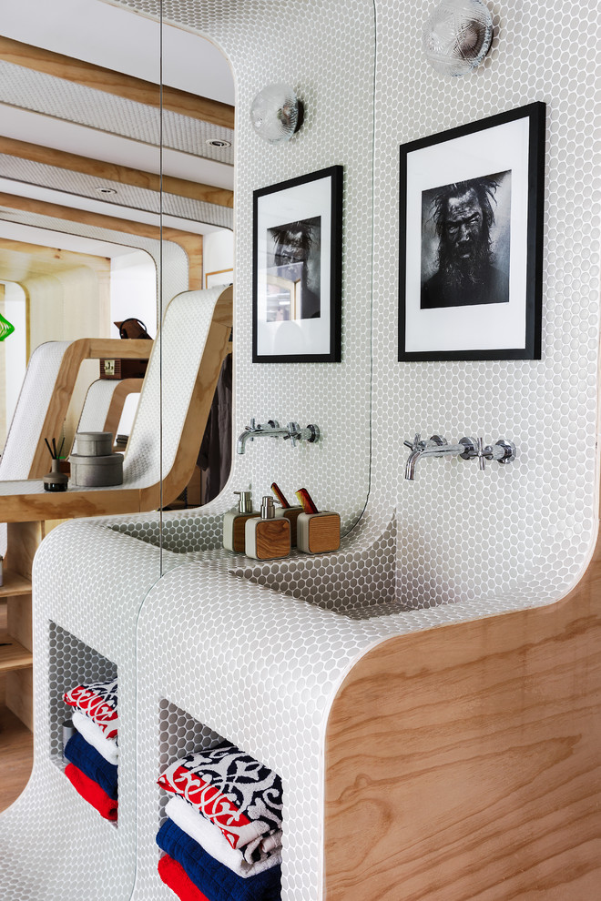 Kleine Moderne Gästetoilette mit grauen Fliesen, integriertem Waschbecken, offenen Schränken, bunten Wänden und braunem Holzboden in Sonstige