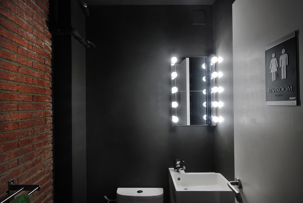 Immagine di un piccolo bagno di servizio minimal con pareti nere e lavabo sospeso