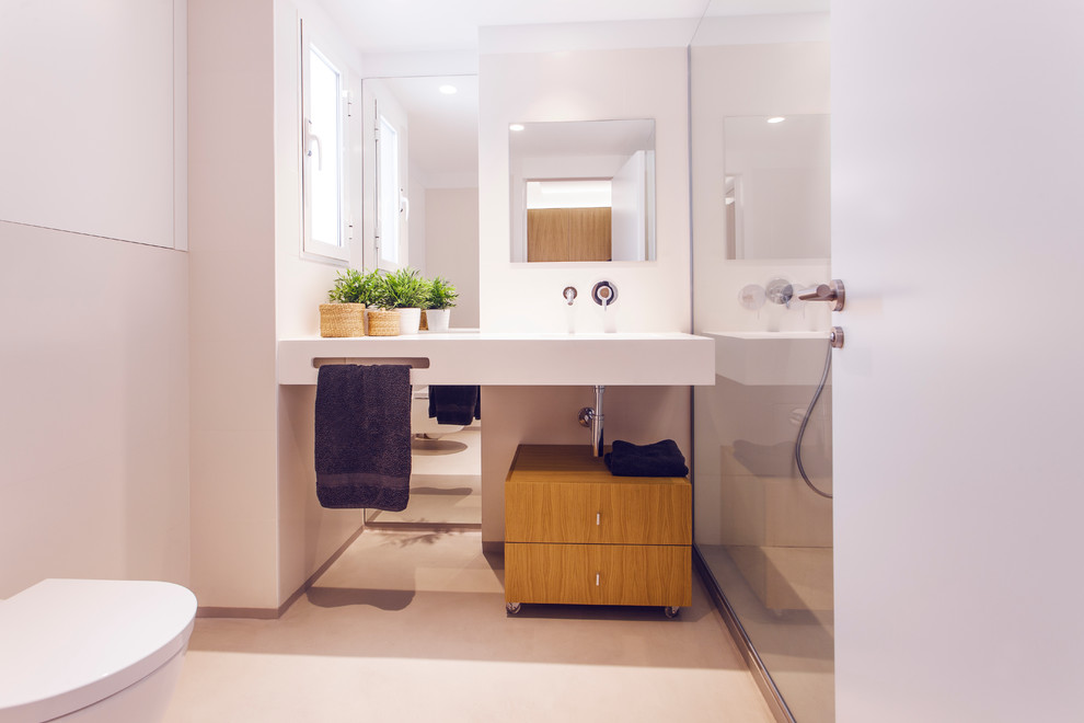 Immagine di un bagno di servizio scandinavo con WC monopezzo, pareti bianche e lavabo integrato