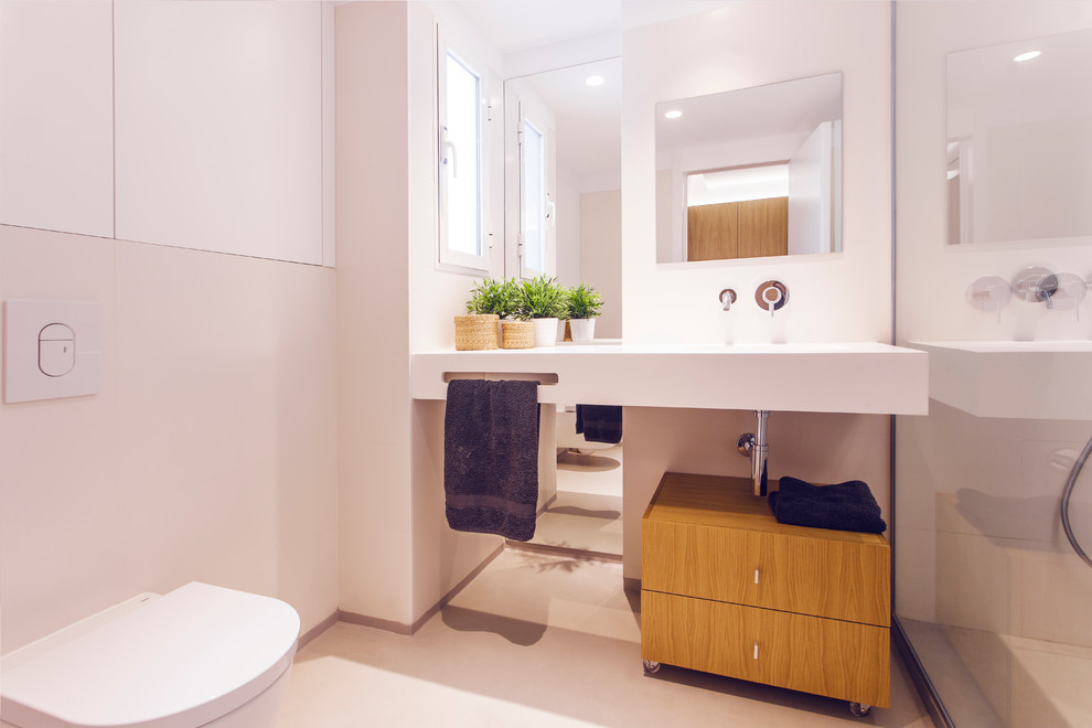 Imagen de aseo nórdico de tamaño medio con armarios tipo mueble, puertas de armario de madera oscura, sanitario de pared, paredes blancas y lavabo suspendido