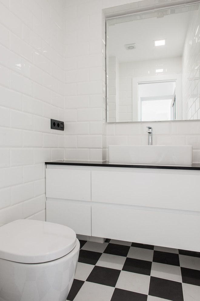 Photo of a small contemporary cloakroom in Other with flat-panel cabinets, white cabinets, a one-piece toilet, white walls, ceramic flooring and a vessel sink.