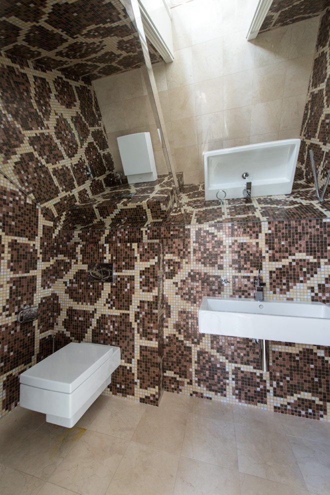 На фото: туалет в современном стиле с инсталляцией, коричневой плиткой, плиткой мозаикой и подвесной раковиной