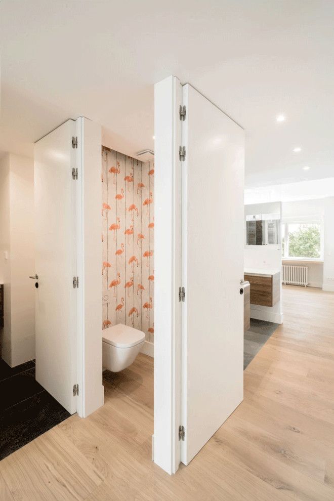 Idée de décoration pour un WC suspendu nordique de taille moyenne avec un carrelage noir, du carrelage en ardoise, un mur multicolore, un sol en bois brun, une vasque et un sol marron.