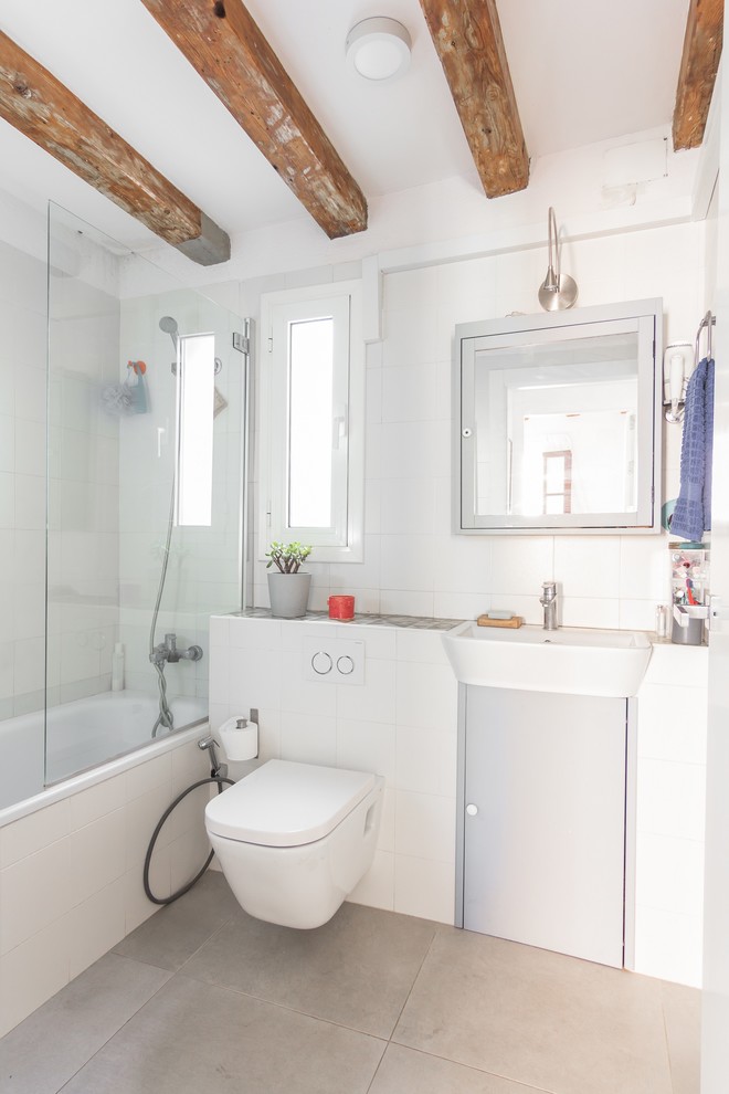 バルセロナにある低価格の小さなコンテンポラリースタイルのおしゃれな浴室 (フラットパネル扉のキャビネット、壁掛け式トイレ、白いタイル、セラミックタイル、白い壁、磁器タイルの床、壁付け型シンク、グレーの床) の写真