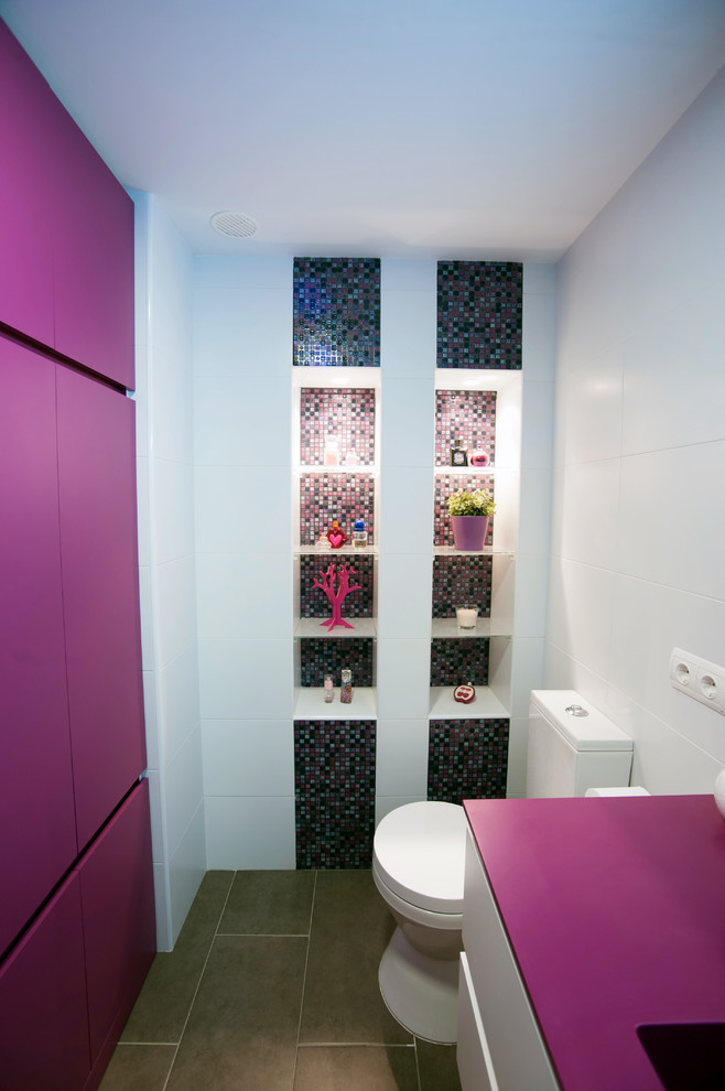 Стильный дизайн: туалет среднего размера в современном стиле с плоскими фасадами, белыми фасадами, раздельным унитазом, разноцветными стенами, полом из керамической плитки и монолитной раковиной - последний тренд