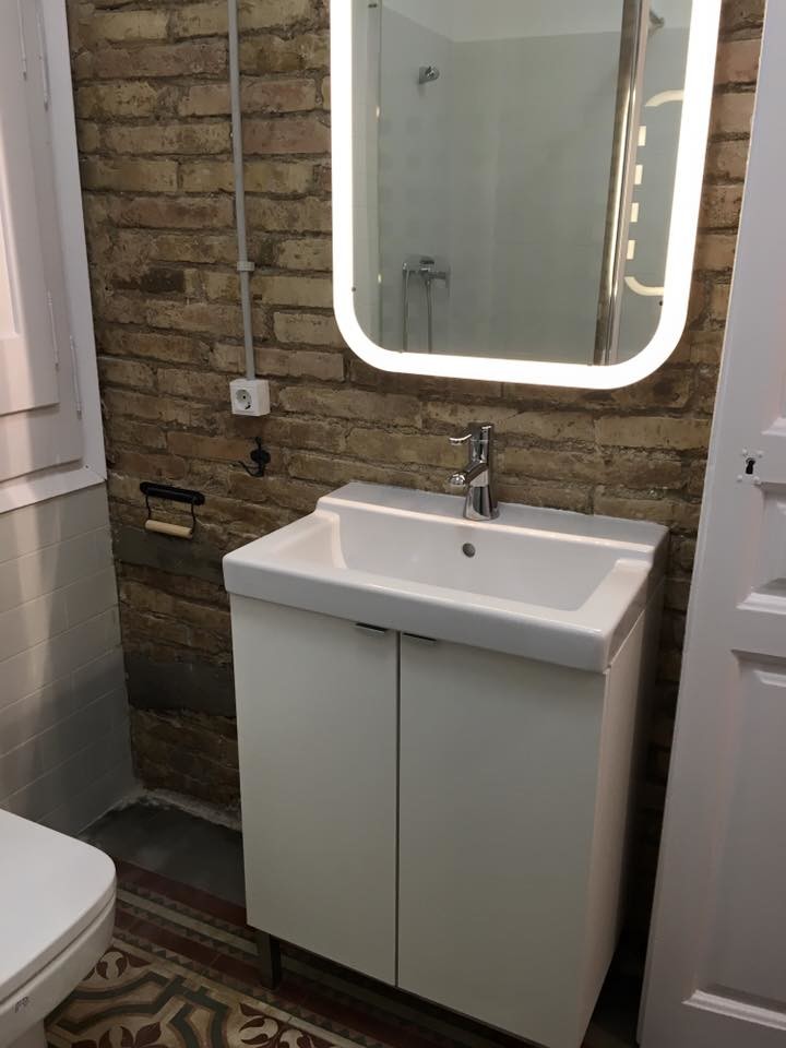 This is an example of a small contemporary cloakroom in Barcelona with flat-panel cabinets, white cabinets, a two-piece toilet, brown walls, ceramic flooring and a wall-mounted sink.
