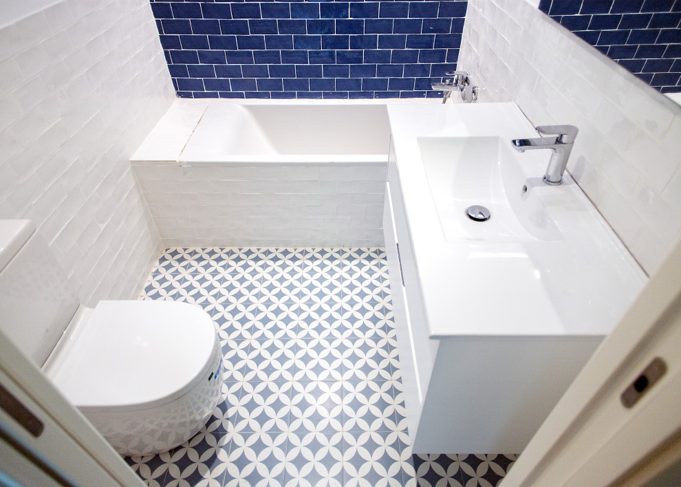 Esempio di un piccolo bagno di servizio contemporaneo con ante bianche, WC monopezzo, piastrelle bianche, piastrelle in ceramica, pavimento con piastrelle in ceramica, pavimento grigio e top bianco