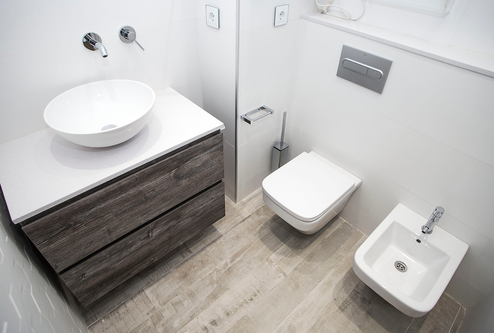 Powder room - mid-sized contemporary white tile light wood floor powder room idea in Barcelona with dark wood cabinets, a two-piece toilet, white walls and a vessel sink