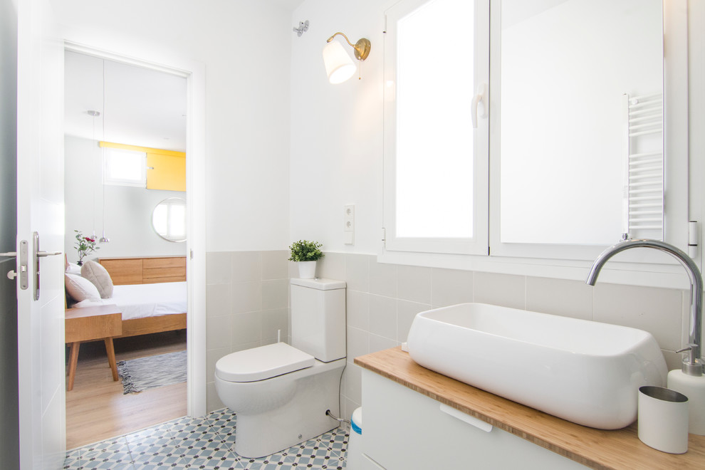 На фото: ванная комната среднего размера в современном стиле с плоскими фасадами, белыми фасадами, раздельным унитазом, керамической плиткой, белыми стенами, полом из керамической плитки и настольной раковиной