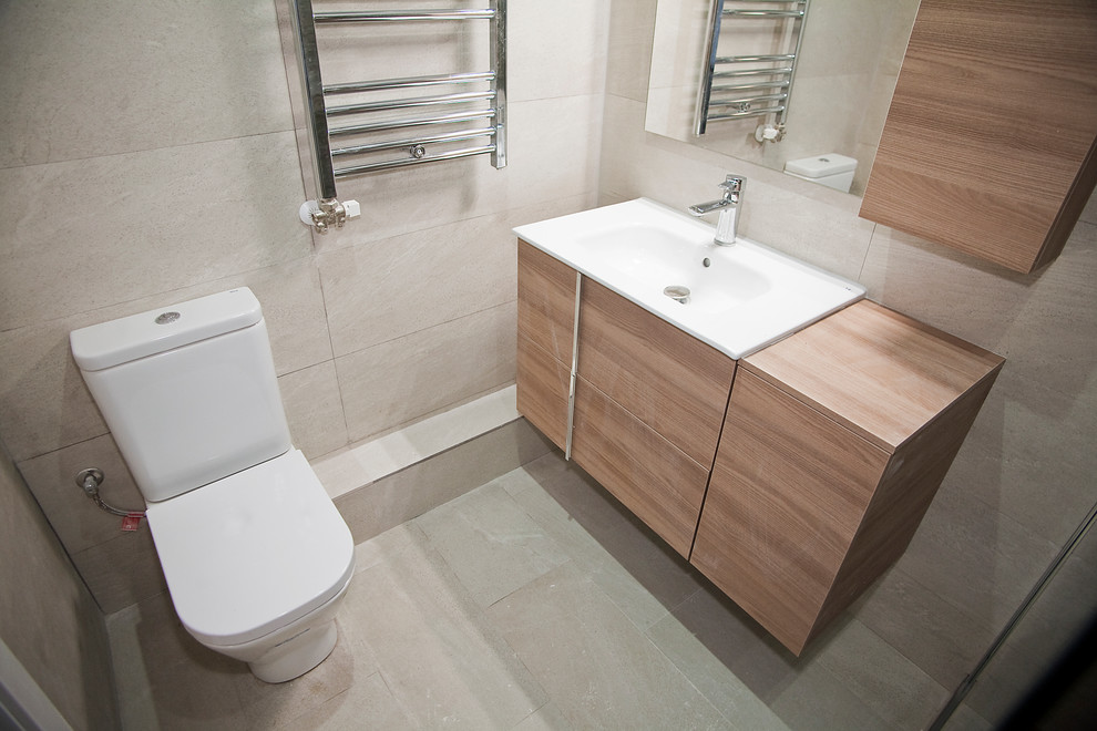 Immagine di un bagno di servizio nordico di medie dimensioni con piastrelle bianche, ante lisce, ante in legno scuro, WC a due pezzi e lavabo da incasso