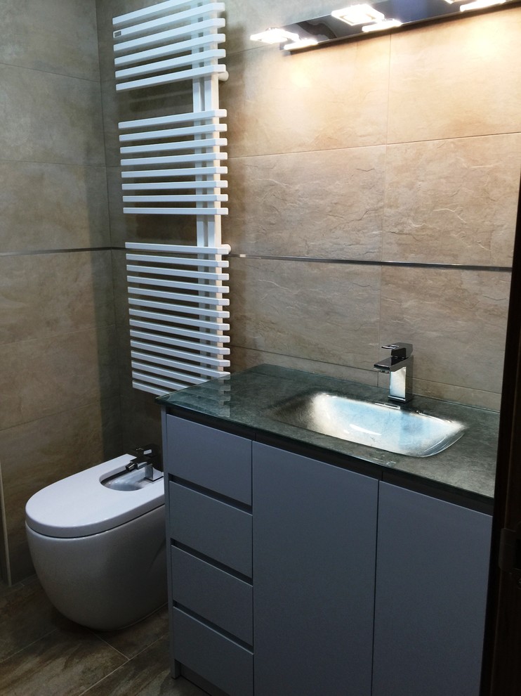 Cette photo montre un petit WC et toilettes moderne avec un placard à porte plane, des portes de placard grises, un lavabo intégré et un bidet.