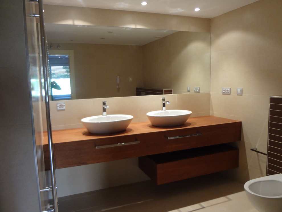 Mittelgroße Moderne Gästetoilette mit flächenbündigen Schrankfronten, hellbraunen Holzschränken, Wandtoilette, beiger Wandfarbe und Aufsatzwaschbecken in Sonstige