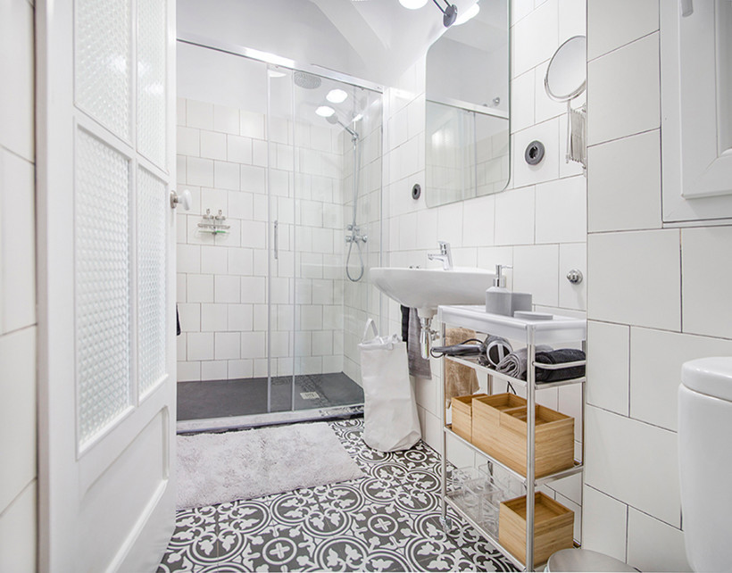 Cette photo montre une petite salle de bain scandinave avec un placard en trompe-l'oeil, des portes de placard grises, WC à poser, un carrelage blanc, des carreaux de céramique, un mur blanc, un sol en carrelage de porcelaine, un lavabo suspendu et un sol noir.