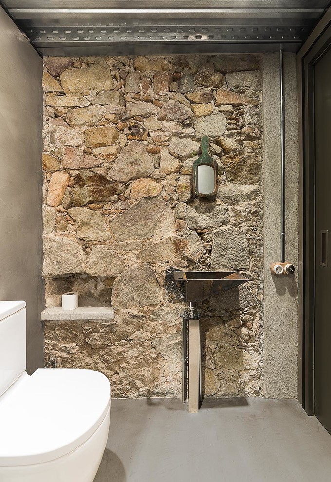 Mittelgroße Industrial Gästetoilette mit grauer Wandfarbe, Betonboden, Wandwaschbecken und Wandtoilette mit Spülkasten in Barcelona