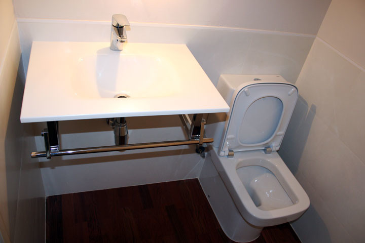 Imagen de aseo clásico renovado pequeño con sanitario de dos piezas, paredes blancas y lavabo suspendido