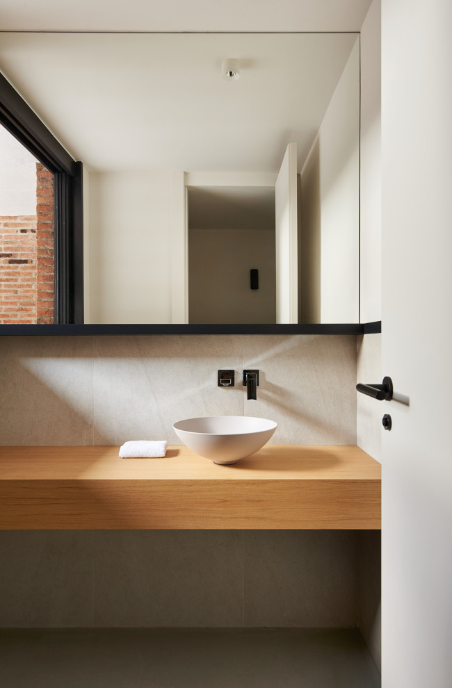 This is an example of a large modern cloakroom in Barcelona with flat-panel cabinets, beige cabinets, beige tiles, ceramic tiles, beige walls, concrete flooring, a vessel sink, wooden worktops, grey floors, beige worktops and a built in vanity unit.
