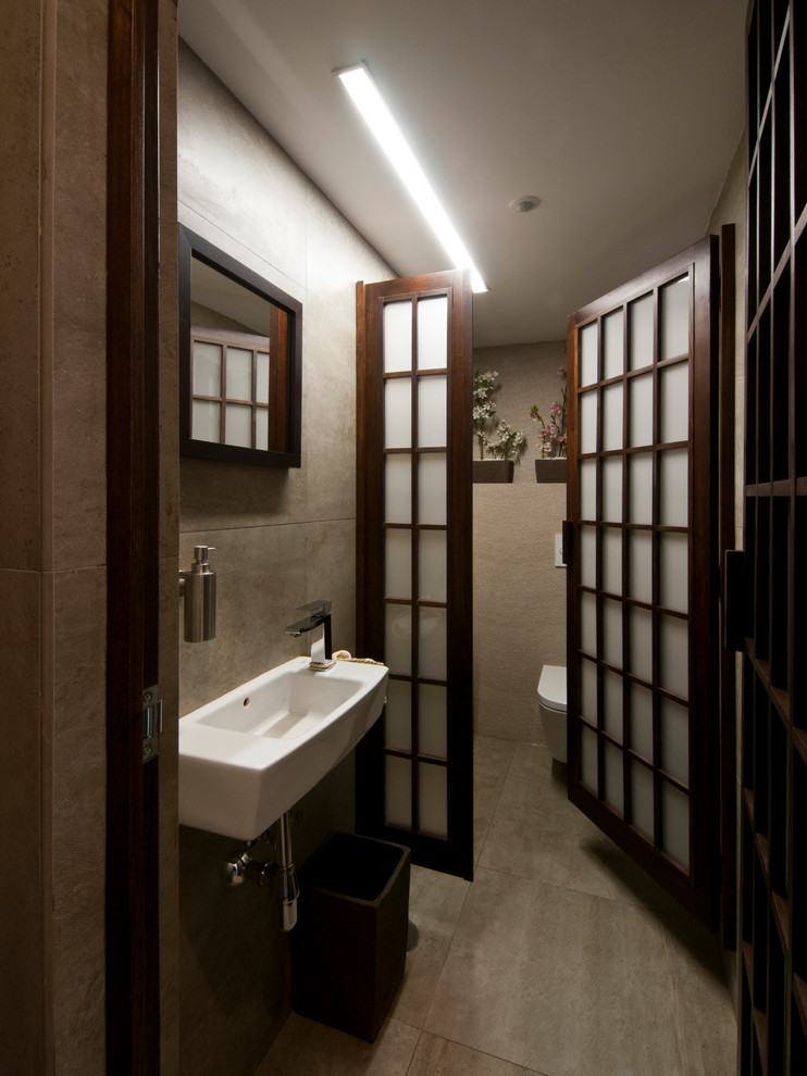 Esempio di un bagno di servizio etnico di medie dimensioni con pareti beige e lavabo sospeso