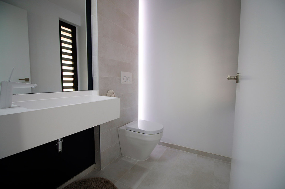 Idéer för små funkis vitt toaletter, med ett urinoar, grå kakel, keramikplattor, grå väggar, klinkergolv i keramik, ett integrerad handfat, bänkskiva i akrylsten och grått golv