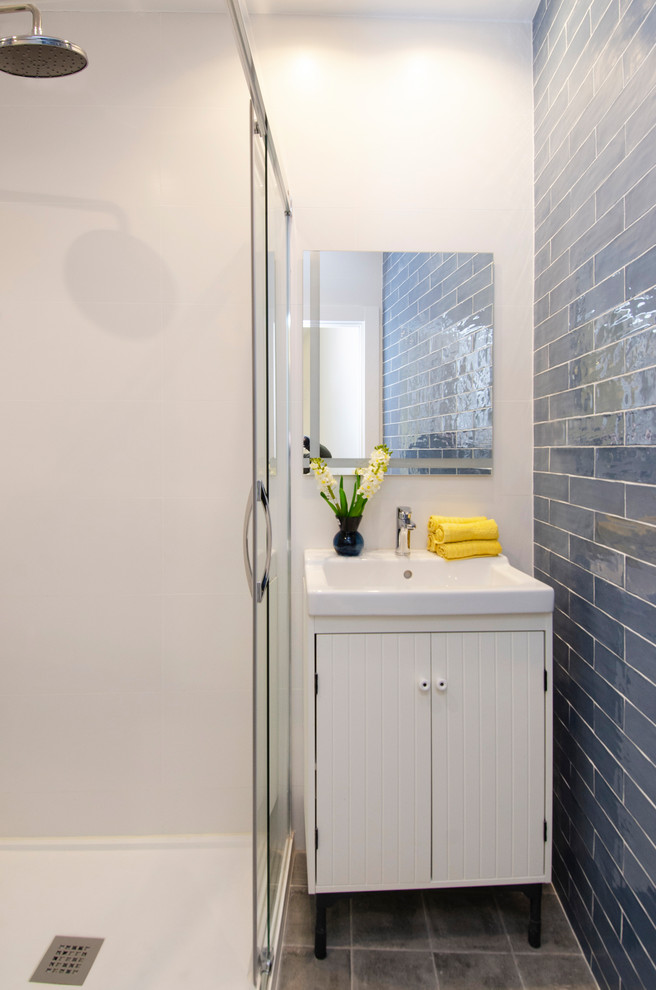 На фото: маленький туалет в современном стиле с фасадами островного типа, белыми фасадами, синей плиткой, керамической плиткой, белыми стенами, полом из керамической плитки, накладной раковиной и серым полом для на участке и в саду