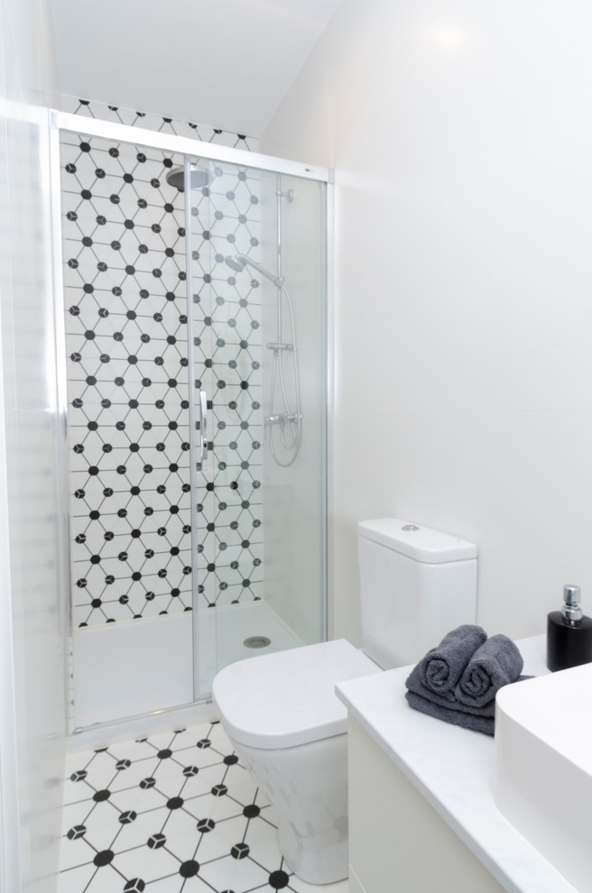 Idéer för ett mellanstort modernt vit toalett, med möbel-liknande, vita skåp, vit kakel, porslinskakel, vita väggar, klinkergolv i porslin, ett fristående handfat, marmorbänkskiva och vitt golv