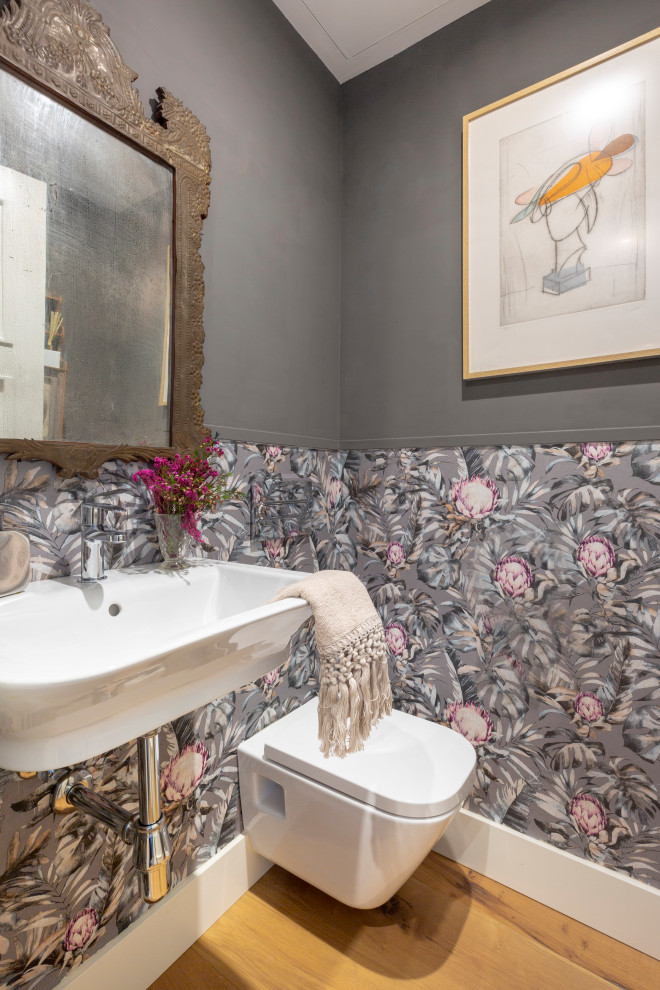 Cette image montre un WC suspendu traditionnel de taille moyenne avec un mur gris, parquet clair et un lavabo suspendu.