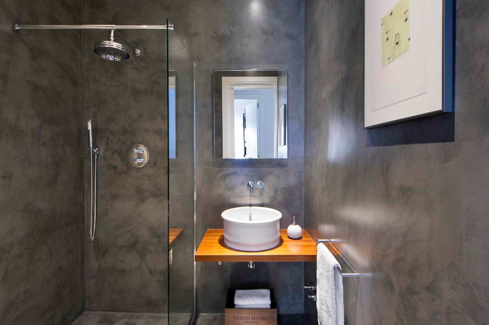 Esempio di un bagno di servizio design di medie dimensioni con pareti grigie, lavabo a bacinella, top in legno, pavimento in cemento e top marrone