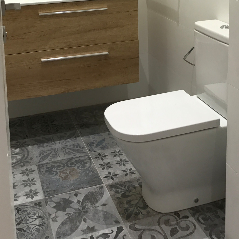 Exemple d'un petit WC et toilettes moderne en bois brun avec WC à poser, un carrelage multicolore, des carreaux de porcelaine, un mur blanc, un sol en carrelage de porcelaine, un lavabo posé et un sol multicolore.