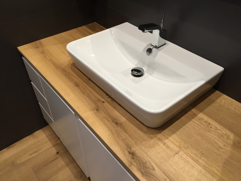 マドリードにある低価格の小さなコンテンポラリースタイルのおしゃれなトイレ・洗面所 (ベッセル式洗面器、木製洗面台) の写真