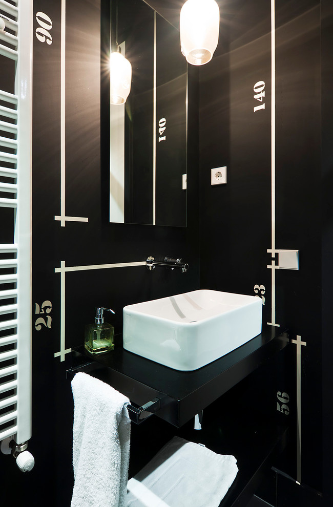 Foto på ett litet funkis toalett, med ett fristående handfat, öppna hyllor, svarta skåp och svarta väggar