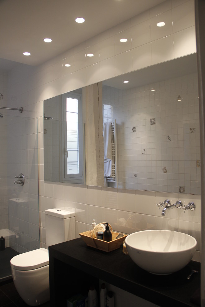 Exemple d'un WC et toilettes tendance de taille moyenne avec WC à poser, un carrelage noir et blanc, des carreaux de céramique, un mur blanc, un sol en carrelage de porcelaine, une vasque, un plan de toilette en granite et un sol noir.