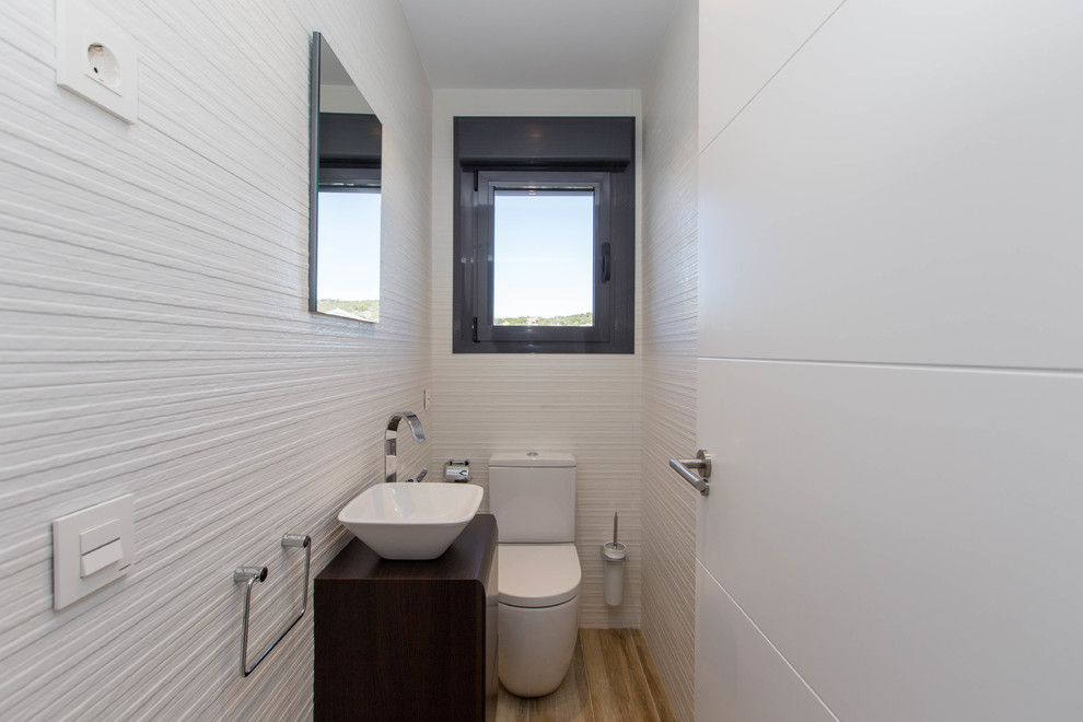Inspiration pour un petit WC et toilettes minimaliste avec WC séparés, un mur blanc, un sol en bois brun et une vasque.