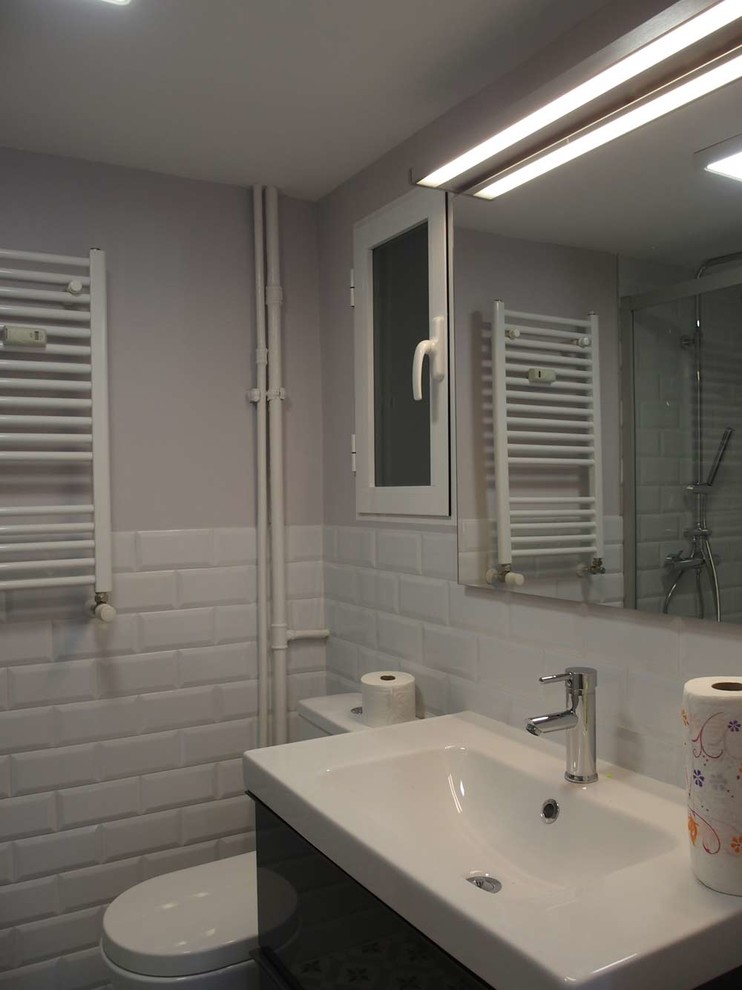 Imagen de aseo retro de tamaño medio con armarios con paneles lisos, sanitario de dos piezas, paredes blancas y lavabo integrado