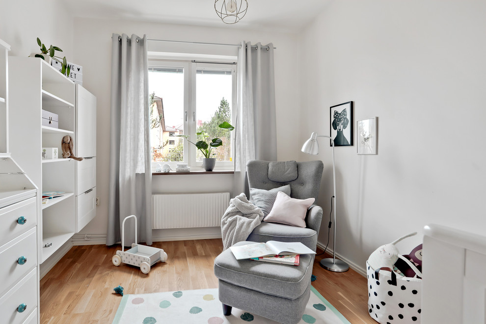 ヨーテボリにある中くらいな北欧スタイルのおしゃれな赤ちゃん部屋 (白い壁、無垢フローリング、男女兼用、茶色い床) の写真