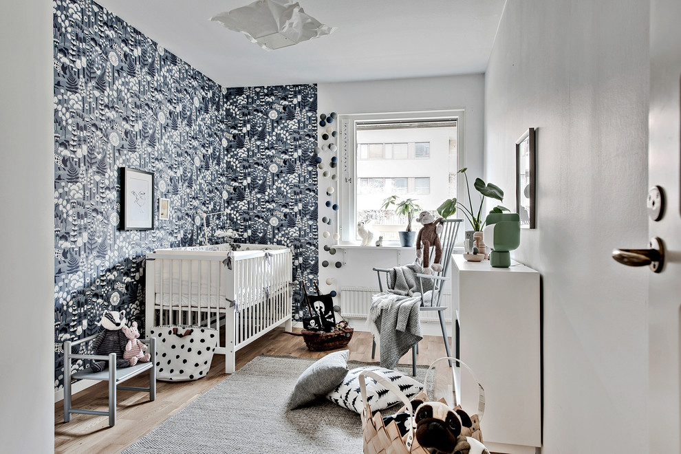 Cette image montre une chambre de bébé nordique avec un mur noir et sol en stratifié.